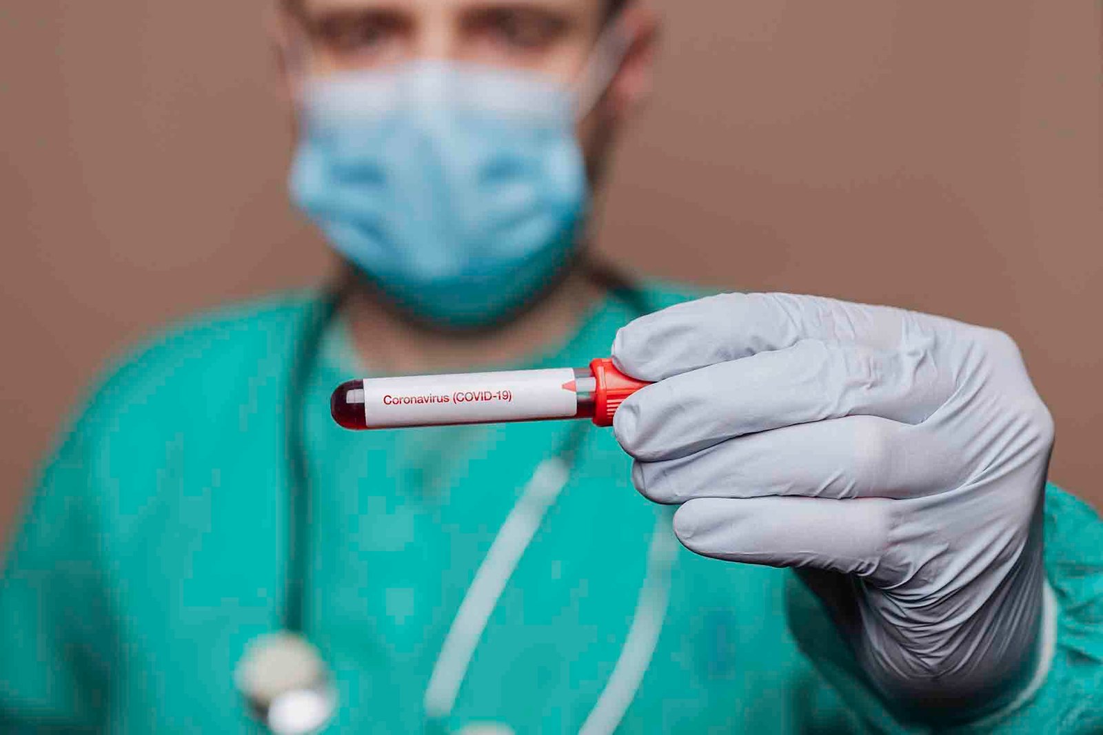 Surgeon holding a covid-19 test tube
